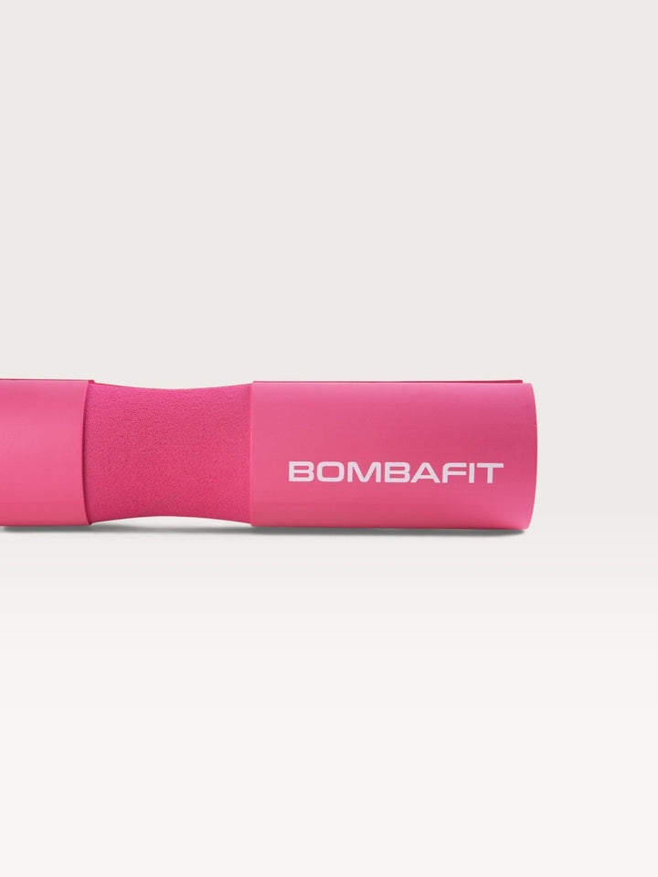 Bilanciere imbottito Bombafit di colore fucsia con logo stampato, ideale per proteggere il collo durante il sollevamento