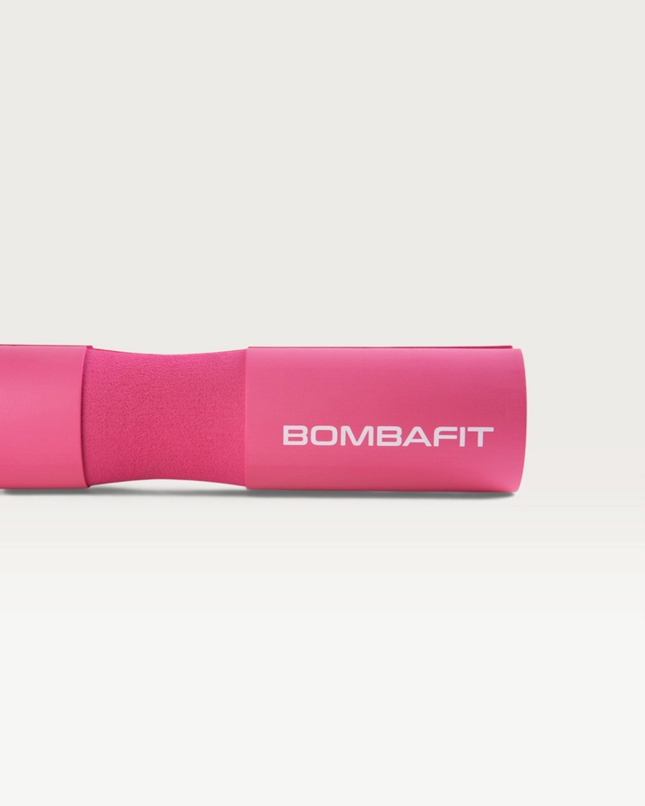 Bilanciere imbottito Bombafit di colore fucsia con logo stampato, ideale per proteggere il collo durante il sollevamento