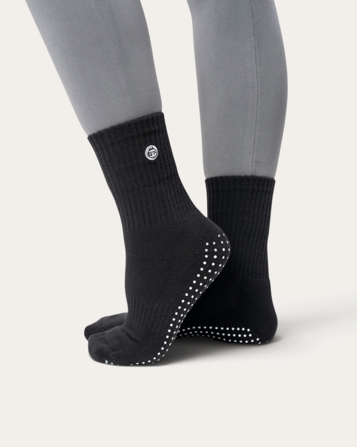 Calzini antiscivolo neri Bombafit con suola grip in silicone per yoga e pilates, indossati con polsino a coste