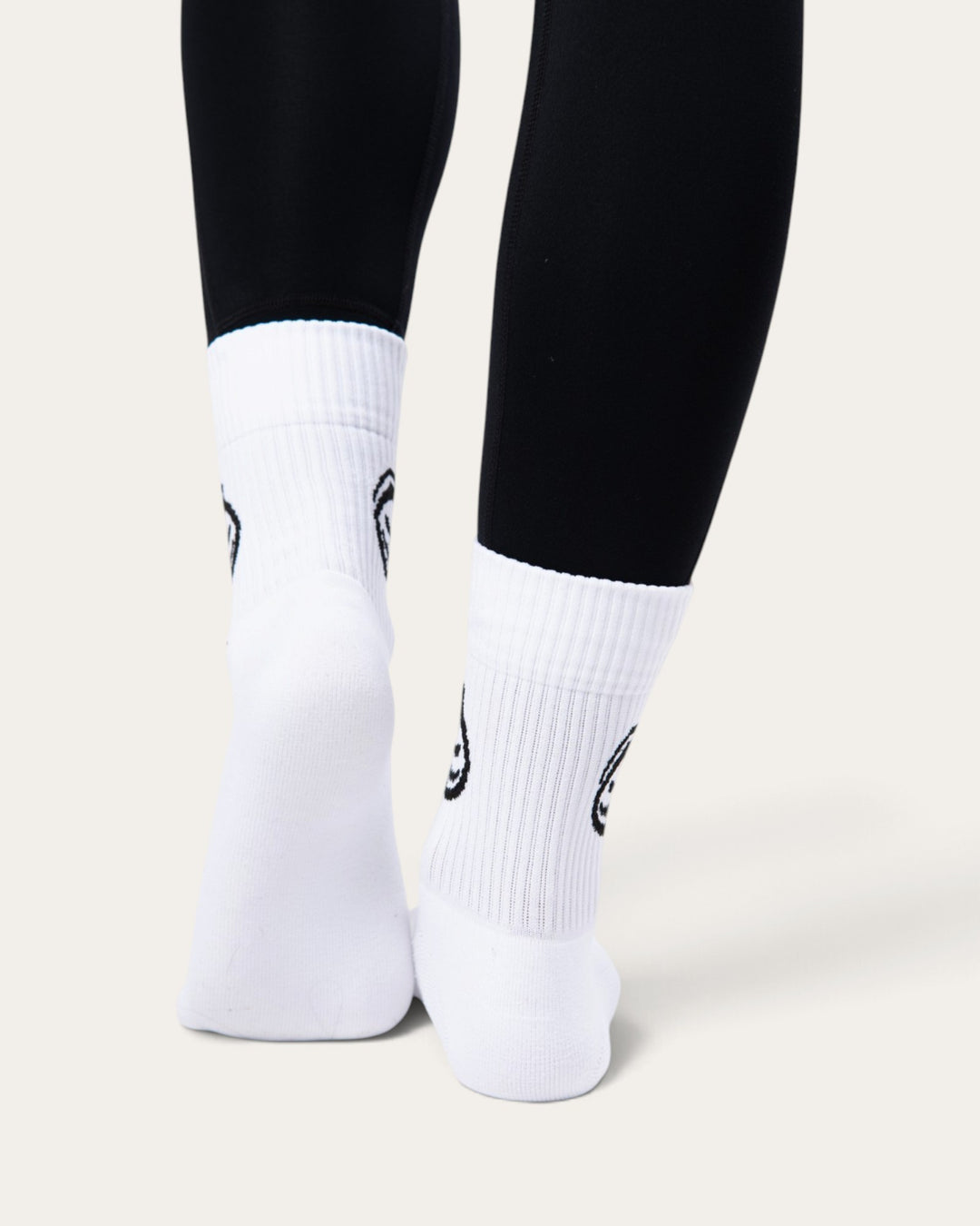 Calzini sportivi Bombafit bianchi a coste con stampa ectoplasma nera indossati con leggings neri