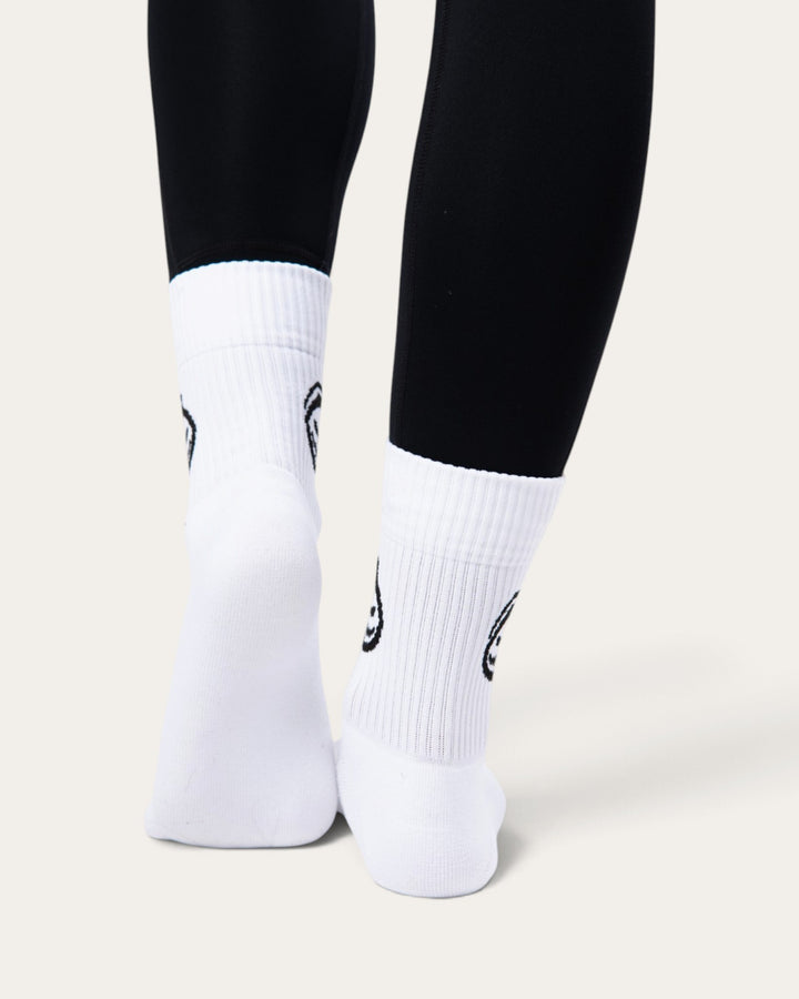 Calzini sportivi Bombafit bianchi a coste con stampa ectoplasma nera indossati con leggings neri