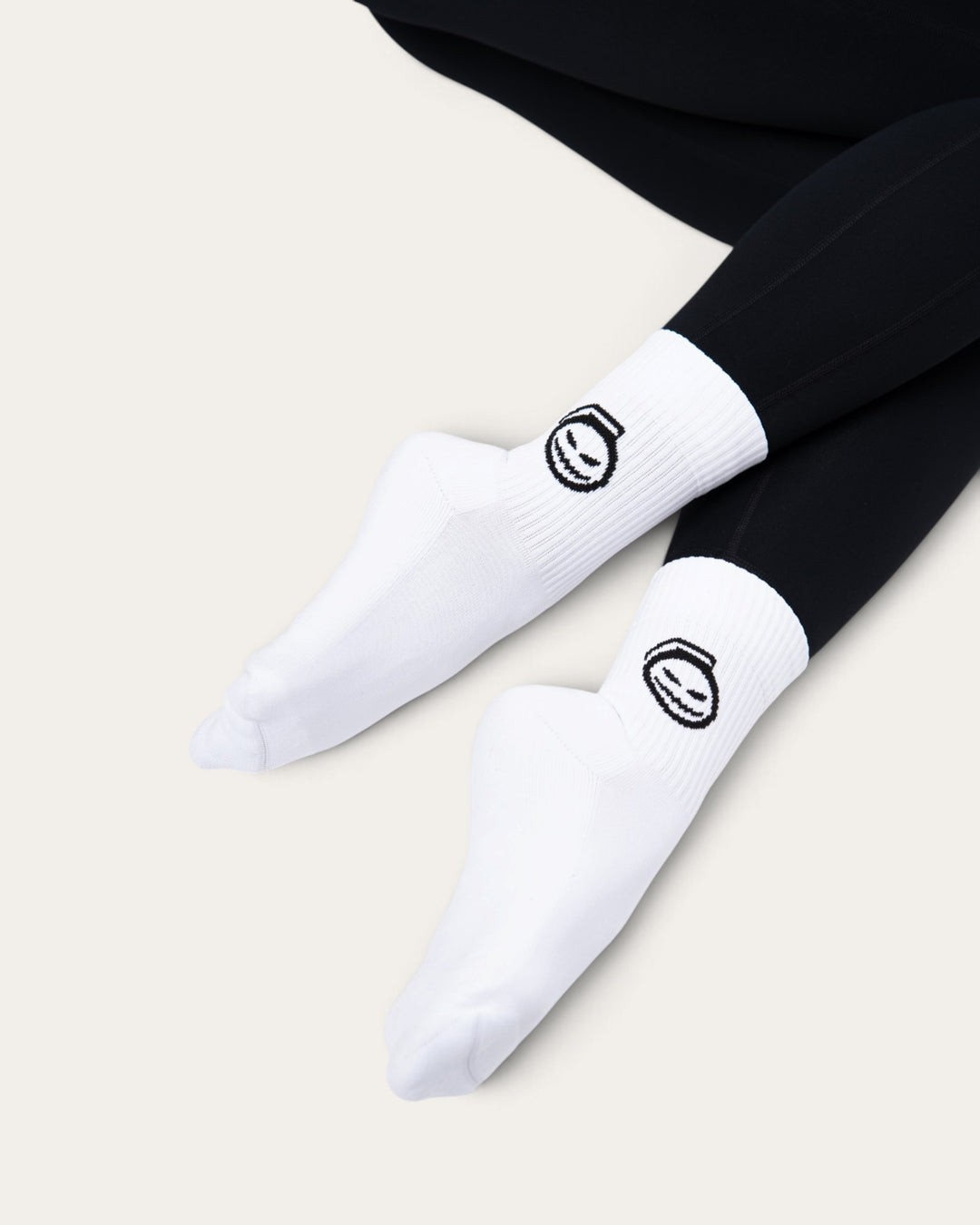 Calzini sportivi bianchi Bombafit con stampa ectoplasma nera, indossati con leggings neri su sfondo neutro