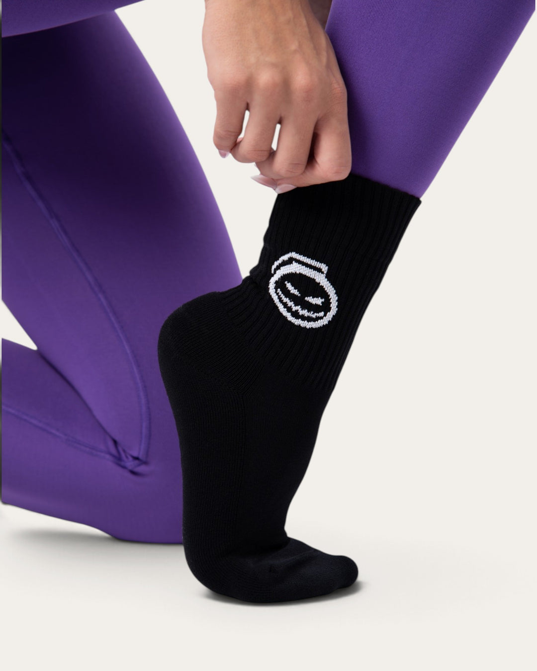 Calzini sportivi neri Bombafit con grafica bianca a tema Halloween indossati con leggings viola