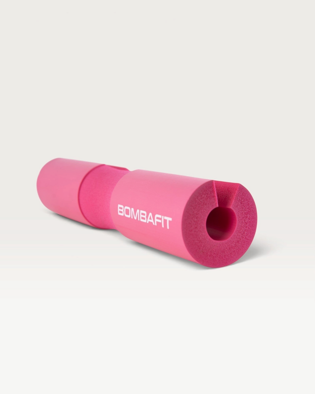 Cuscinetto imbottito per bilanciere Bombafit di colore fucsia, ideale per proteggere il collo durante gli squat.