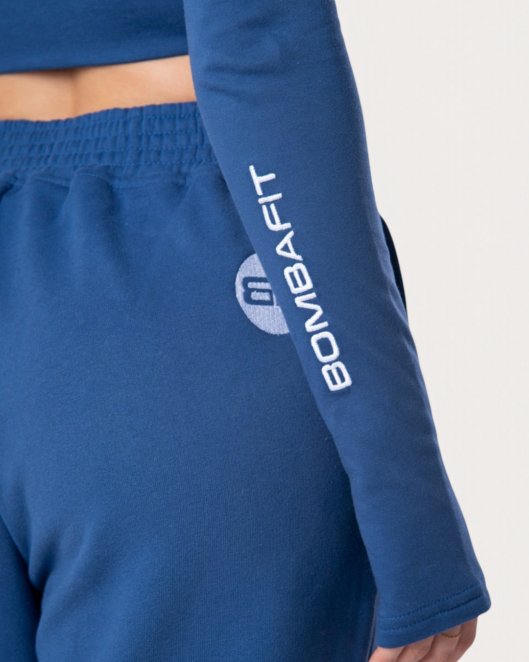 Dettaglio della manica della felpa corta Bombafit Flux Mini blu reale con logo bianco stampato