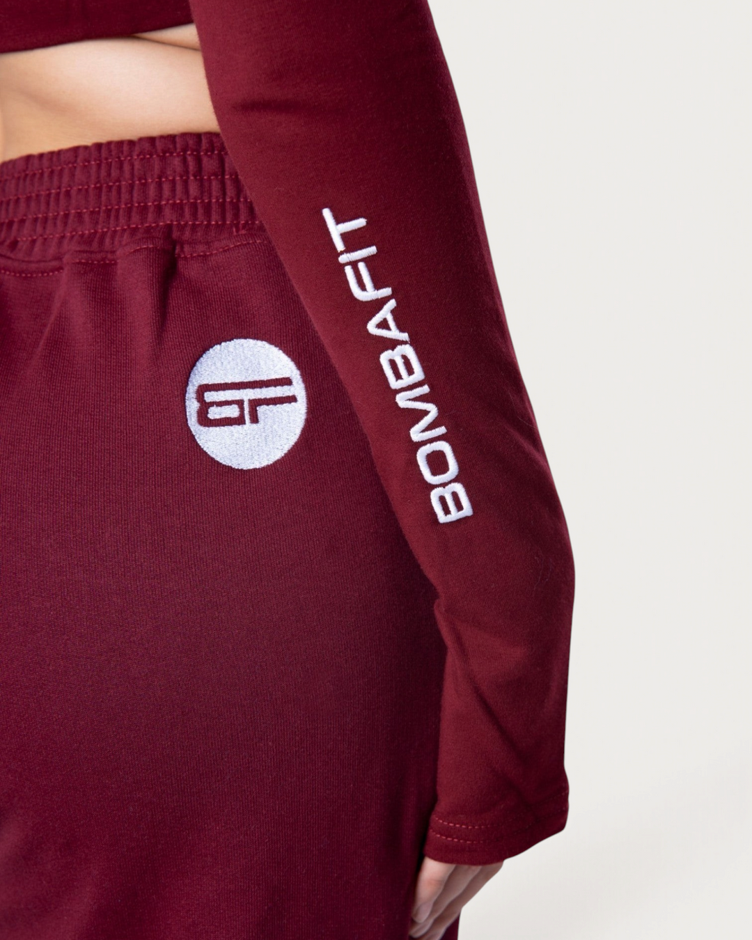 Dettaglio della manica della felpa Bombafit Flux Mini color bordeaux con logo ricamato bianco
