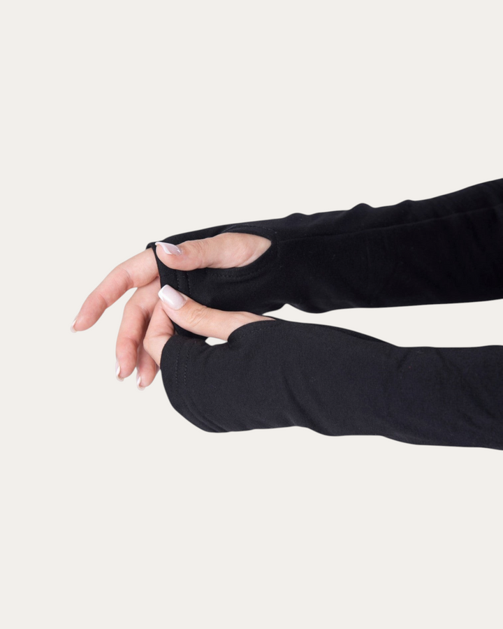 Dettaglio delle maniche nere Bombafit Flux Mini Hoodie con fori per i pollici su sfondo neutro
