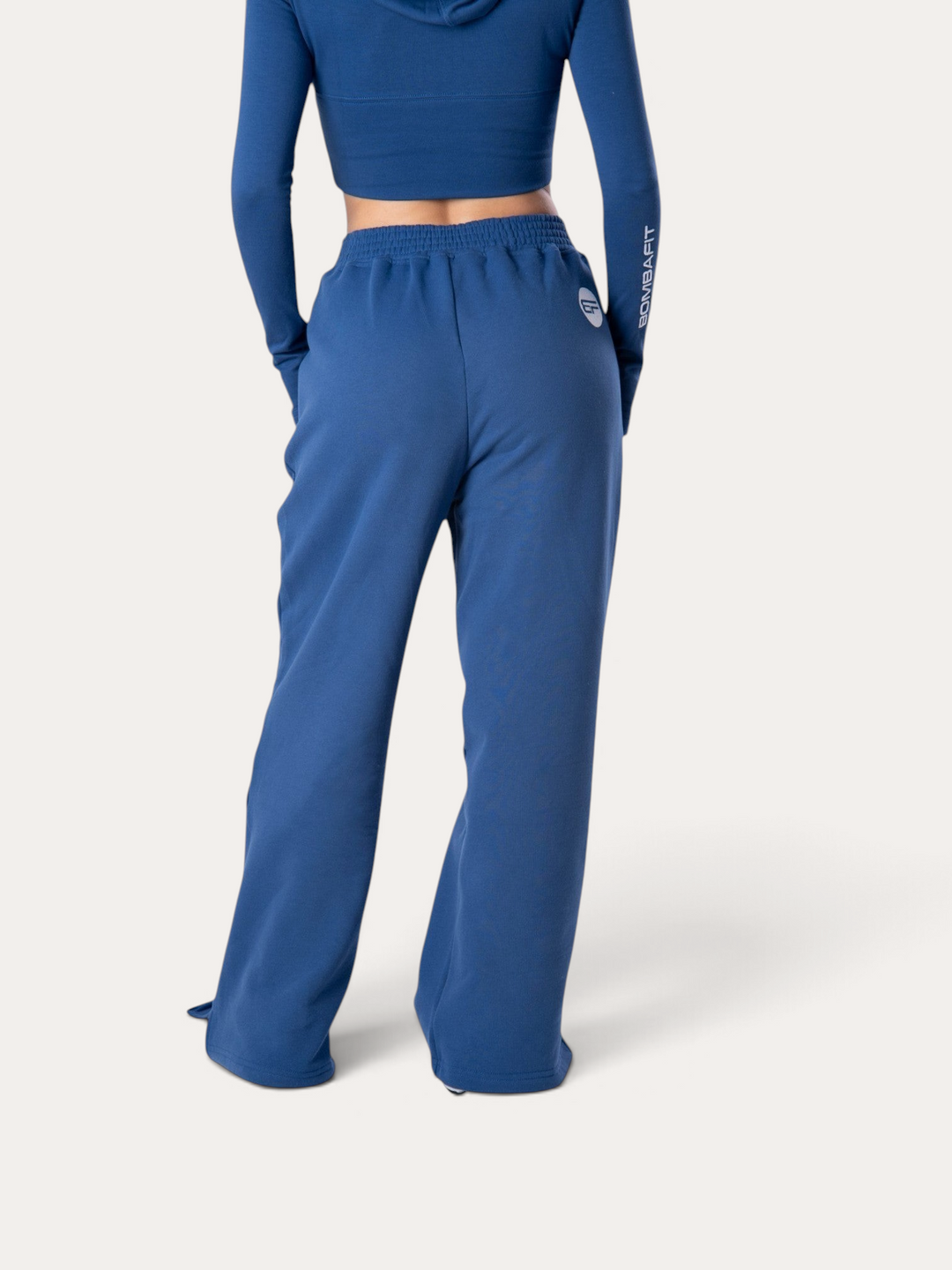 Vista posteriore di pantaloni della tuta Bombafit Flux blu royal con vita elasticizzata e logo sul fianco