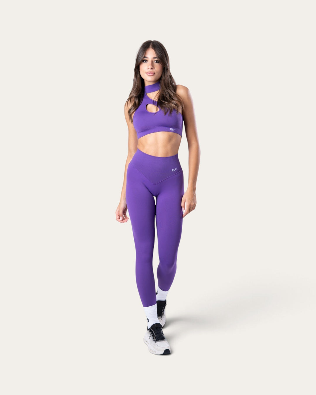 Modella indossa leggings Bombafit Nyx viola push-up senza cuciture con top sportivo coordinato su sfondo neutro