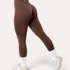 Leggings Bombafit Comfort Seamless marroni a vita alta con effetto push-up, indossati di profilo su sfondo neutro