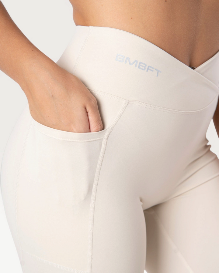 Leggings Bombafit Sense beige a vita alta con dettaglio incrociato, tasca laterale e logo stampato