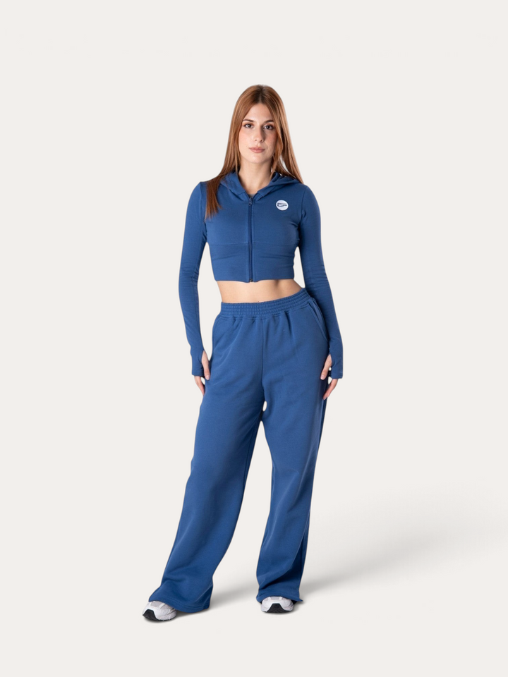 Modella indossa pantaloni della tuta Flux Bombafit blu royal a gamba larga con felpa corta coordinata