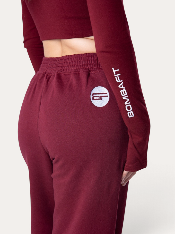 Pantaloni della tuta Bombafit color bordeaux con vita elasticizzata e logo ricamato, indossati da una modella