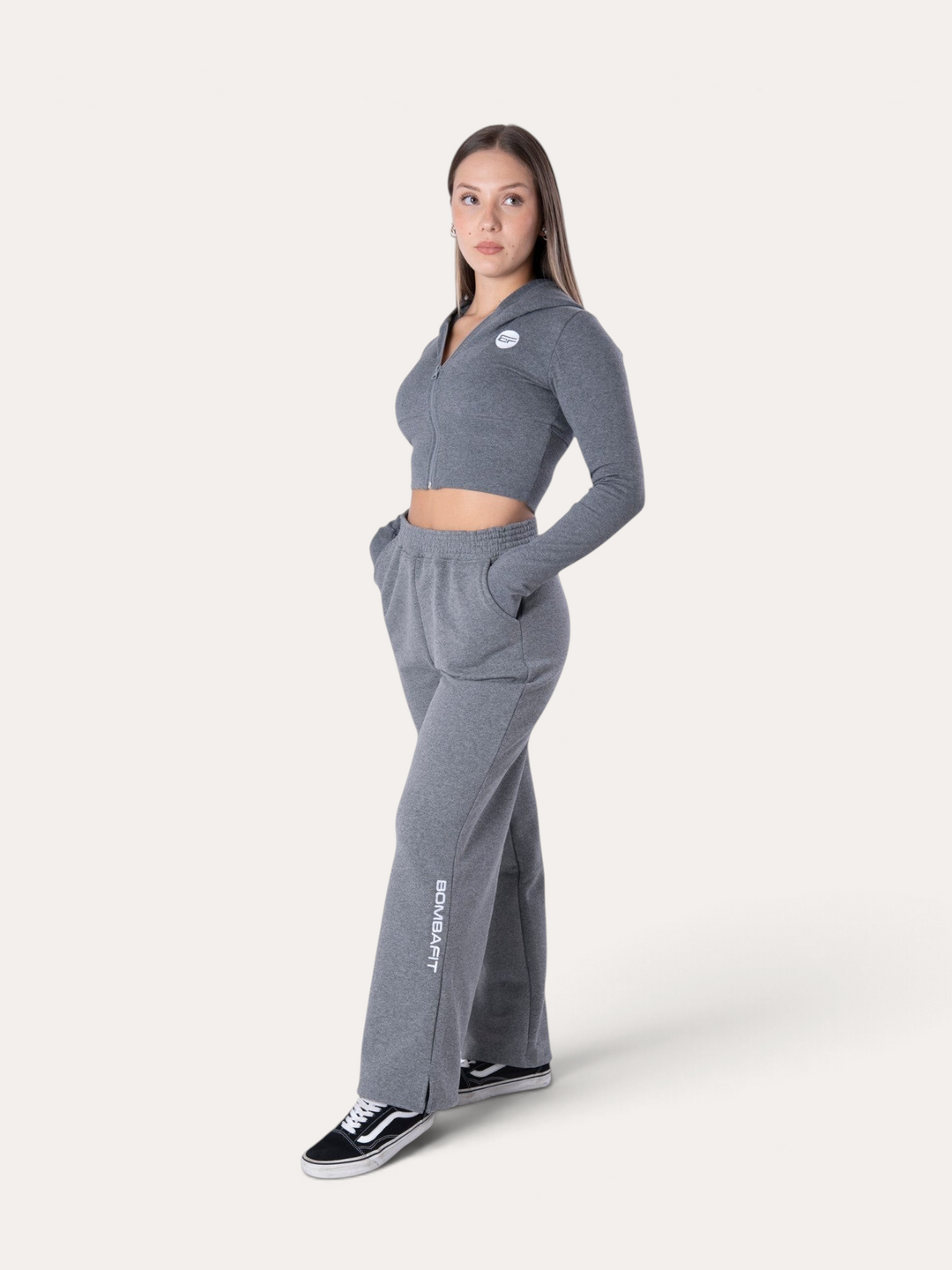 Modella indossa pantaloni della tuta Flux grigio melange Bombafit con felpa corta abbinata e spacchi laterali