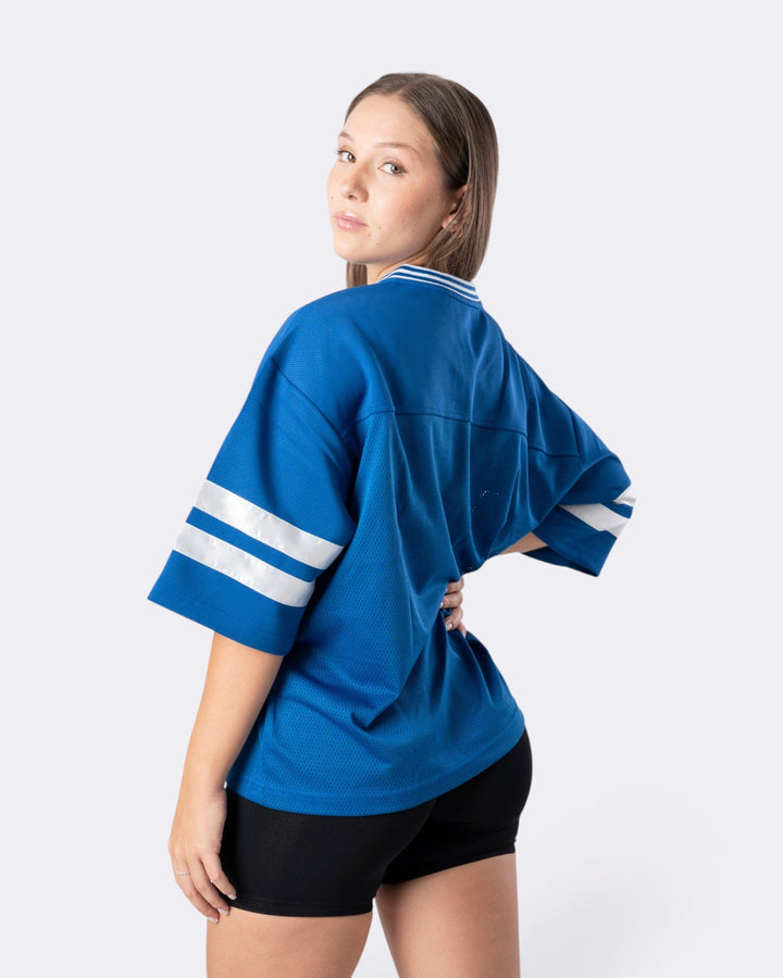 Modella indossa una T-shirt oversize Bombafit blu elettrico in tessuto tecnico con bande bianche sulle maniche