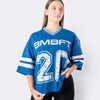 Modella indossa T-shirt oversize Bombafit blu elettrico in stile basket con numero frontale e dettagli a righe