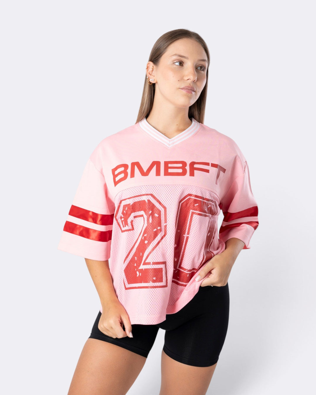 Modella indossa T-shirt Oversize Number Bombafit rosa in tessuto a rete con numero 20 e dettagli stile football