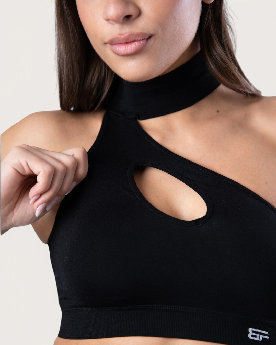 Top sportivo Bombafit nero seamless con design a choker e apertura frontale a goccia indossato da una modella