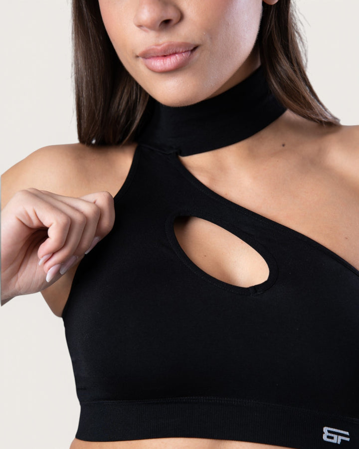 Top sportivo Bombafit nero seamless con design a choker e apertura frontale a goccia indossato da una modella
