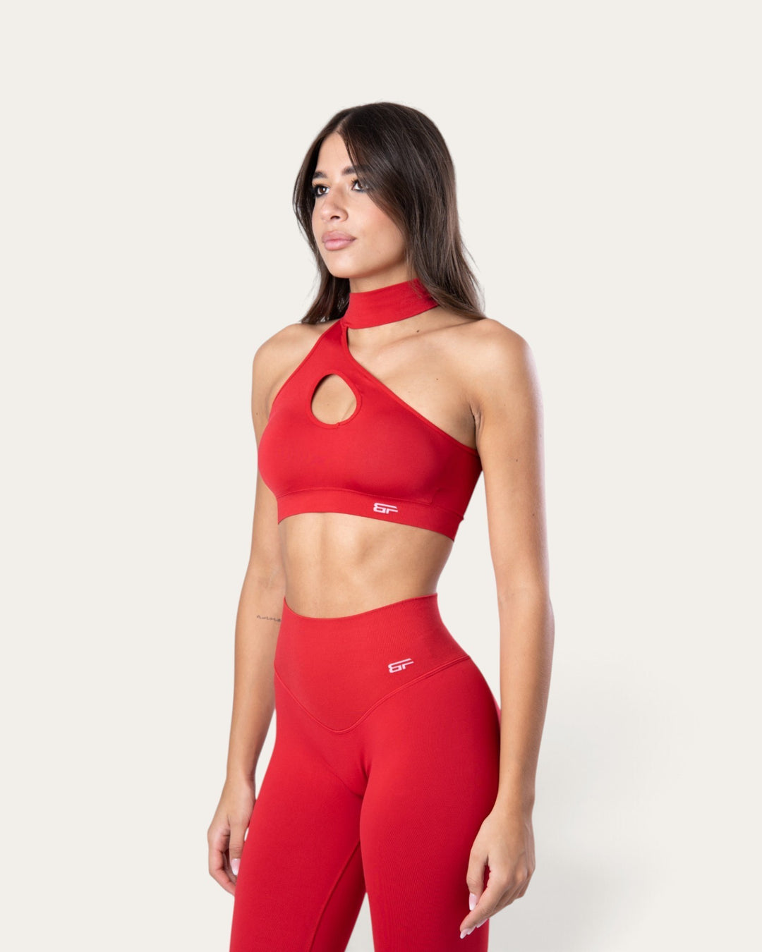 Modella indossa top sportivo Bombafit rosso sangue seamless con design choker e apertura frontale