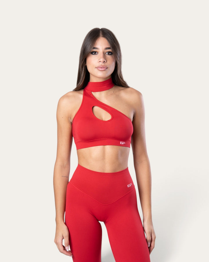 Modella indossa il top sportivo Bombafit choker seamless rosso sangue con design monospalla e apertura sul petto