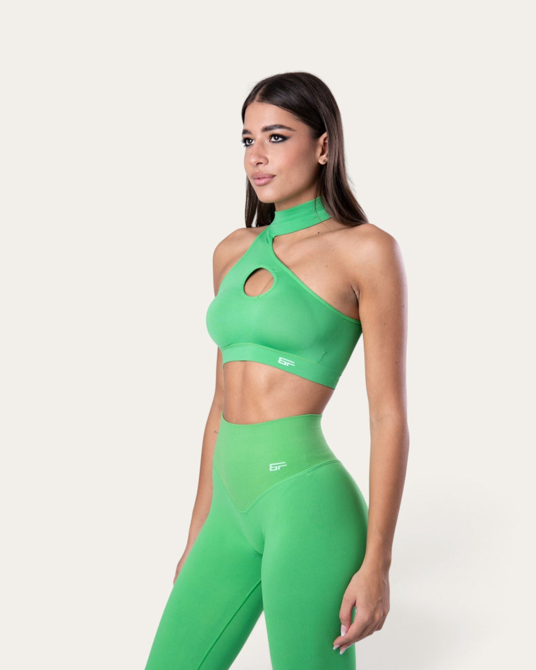 Modella indossa il top sportivo Bombafit choker seamless color verde slime con dettaglio cut-out sul petto