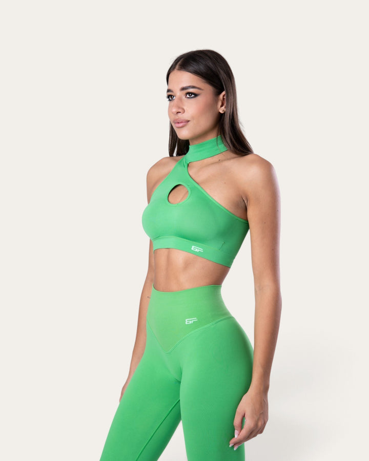Modella indossa il top sportivo Bombafit choker seamless color verde slime con dettaglio cut-out sul petto