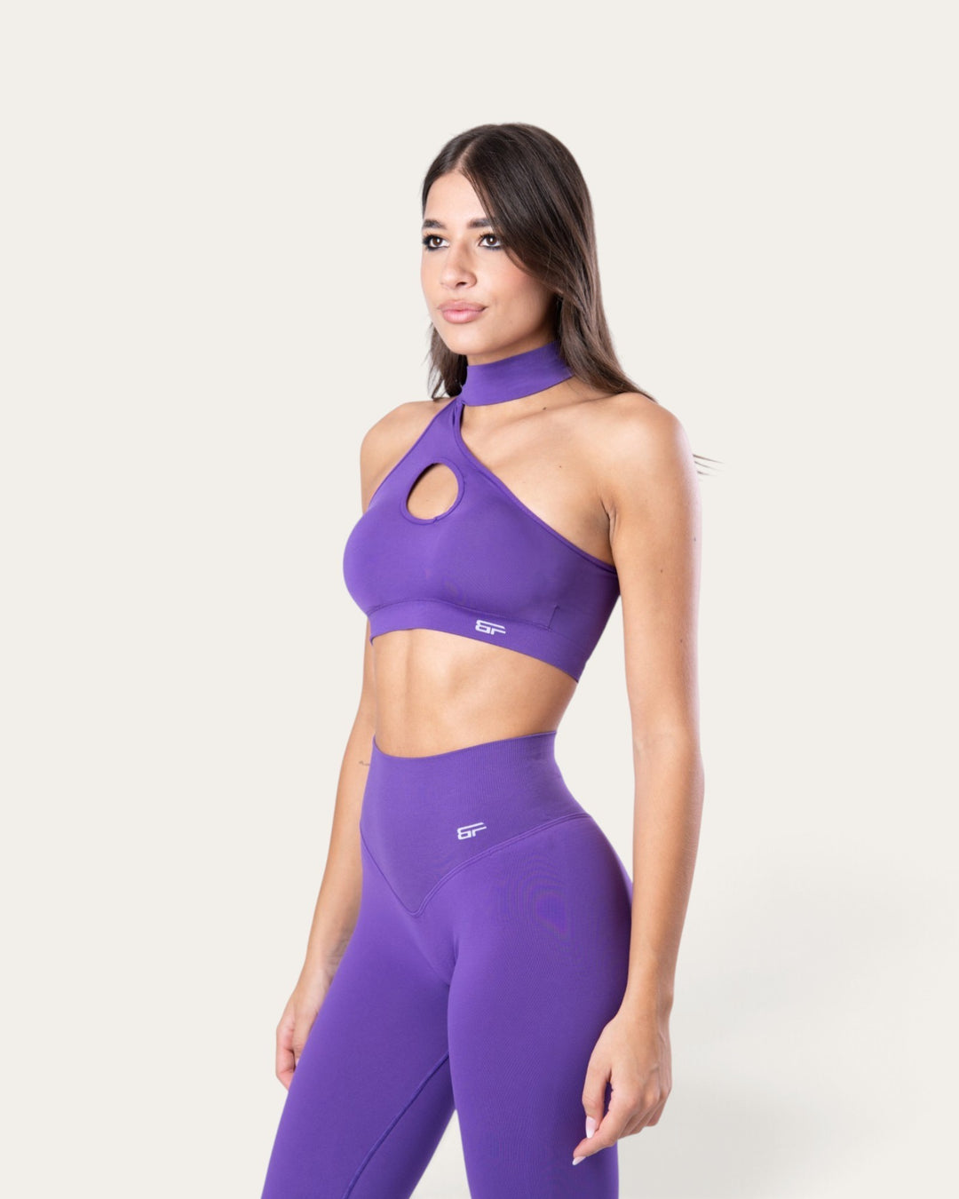 Modella indossa il top sportivo choker seamless viola di Bombafit con dettaglio cut-out sul petto