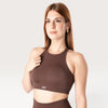 Modella indossa il top sportivo marrone Bombafit Go Seamless con scollo alto e design senza cuciture
