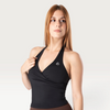 Modella indossa il top sportivo nero Bombafit Sense Halter con scollo all'americana e design incrociato sul davanti