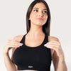 Modella indossa il top sportivo nero Bombafit Active Seamless con design a vogatore e tessuto tecnico traspirante