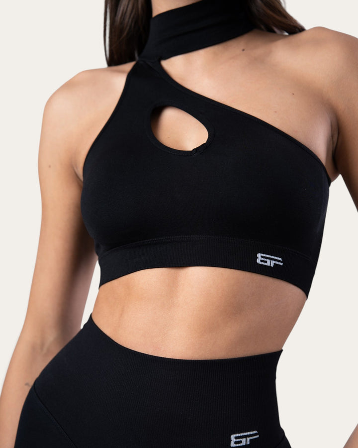 Top sportivo Bombafit nero seamless con design monospalla, dettaglio choker e apertura frontale a goccia
