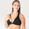 Modella indossa il top sportivo nero Bombafit Sense con spalline incrociate, fascia sottoseno logata ed effetto push-up