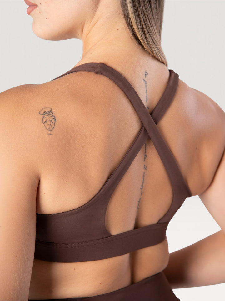Vista posteriore del top sportivo Bombafit Sense marrone con spalline incrociate e tessuto elasticizzato
