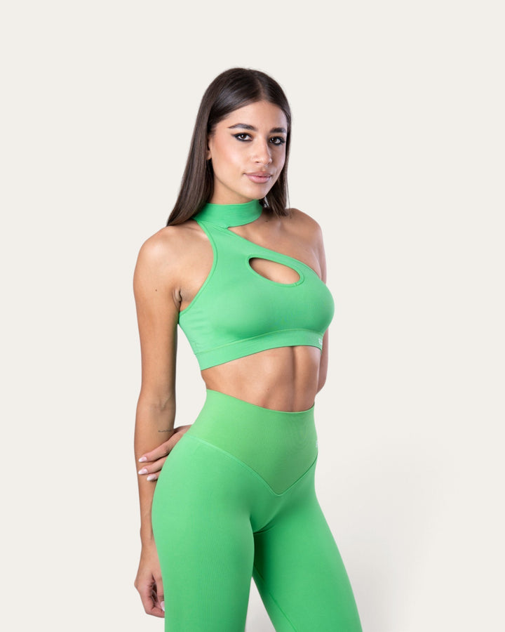 Modella indossa il top sportivo Bombafit Choker Seamless color verde slime con scollo asimmetrico e dettaglio cut-out