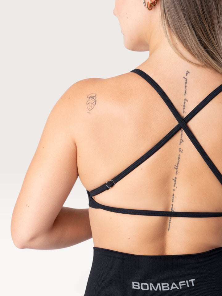 Vista posteriore del top sportivo nero Bombafit con spalline incrociate regolabili e tessuto seamless traspirante
