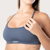 Modella indossa il top sportivo Bombafit Unity Seamless color acciaio con spalline sottili e banda elastica logata