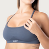 Modella indossa il top sportivo Bombafit Unity Seamless color acciaio con spalline sottili e banda elastica logata