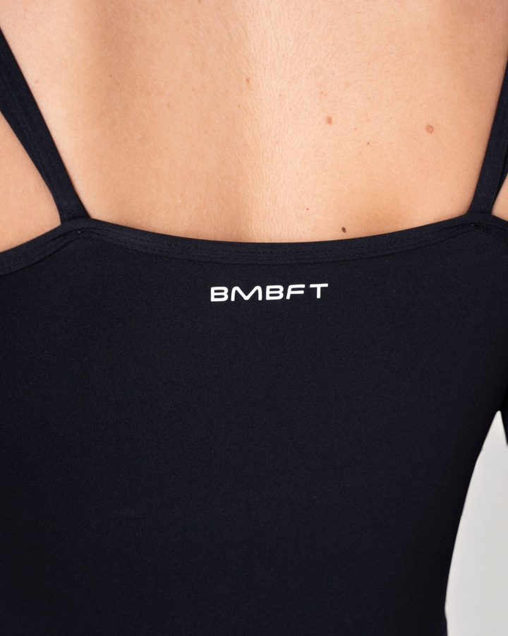 Dettaglio della schiena della tuta intera Diva Jumpsuit nera di Bombafit con logo BMBFT stampato