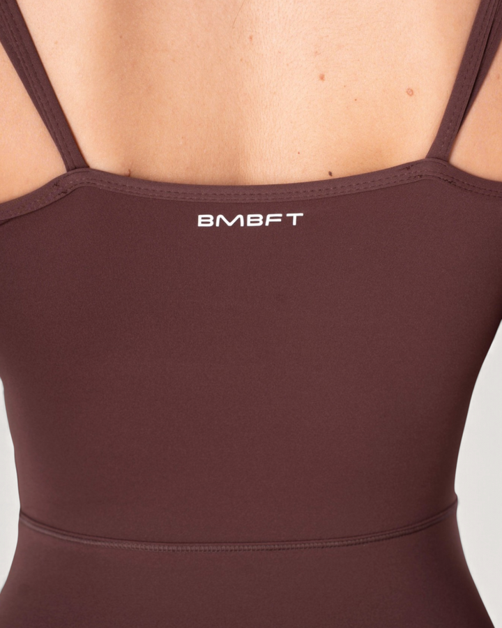 Dettaglio posteriore della tuta intera Diva Bombafit color marrone con spalline sottili e logo BMBFT